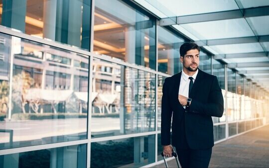 np_Business executive carrying suitcase in airport_41E7Z4_free Business executive carrying a suitcase in the airport waiting for corporate travel transportation