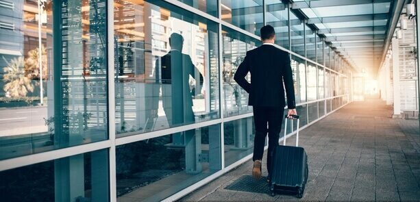 np_Business traveler pulling suitcase in modern airport terminal_0y1NW0_free Airport transfer limousine passenger